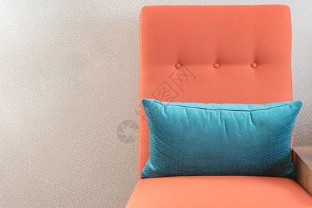 客厅里有蓝色枕头的现代橙色椅子图片