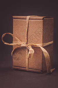 灰色背景上带蝴蝶结的纸质礼盒图片