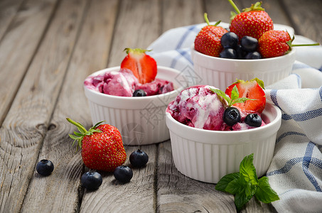 含蓝莓和草莓的冰淇淋以及白碗中的草莓图片