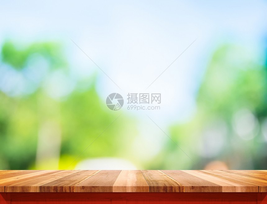 白色棕木质桌顶有阳光和模糊的绿树布基亚背景图片