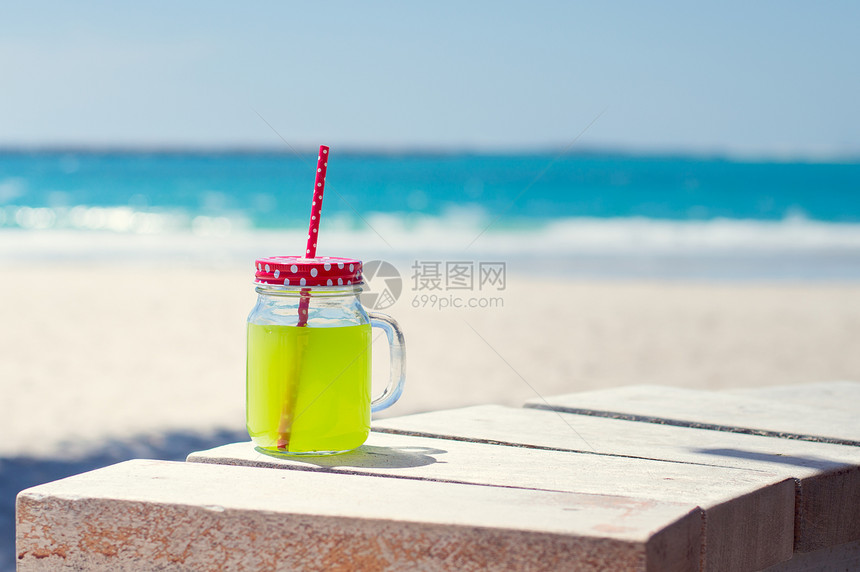 海边线附近的一杯绿色果汁图片