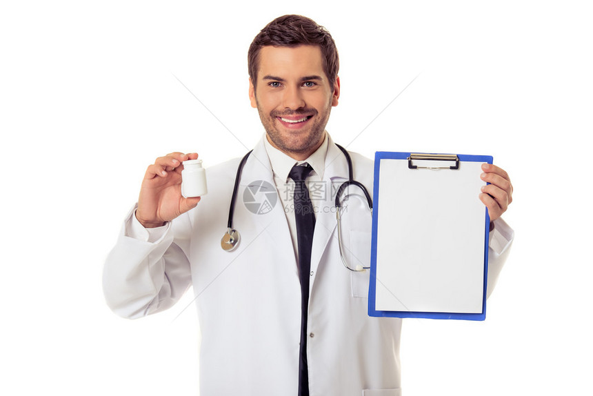 穿着白大褂的英俊医生拿着一个文件夹和一瓶药图片