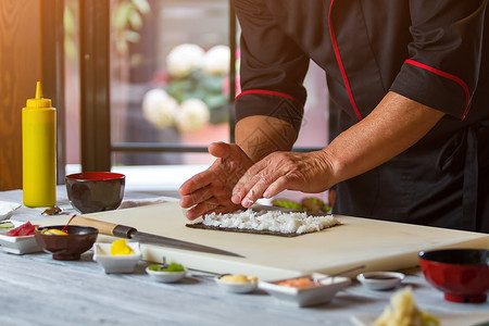 男人的手碰白米饭野叶上的米日本厨师准备寿司香草图片