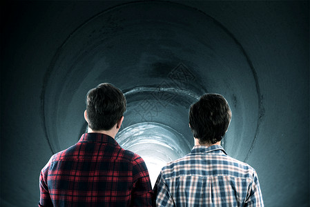 男孩们在隧道里看背景图片