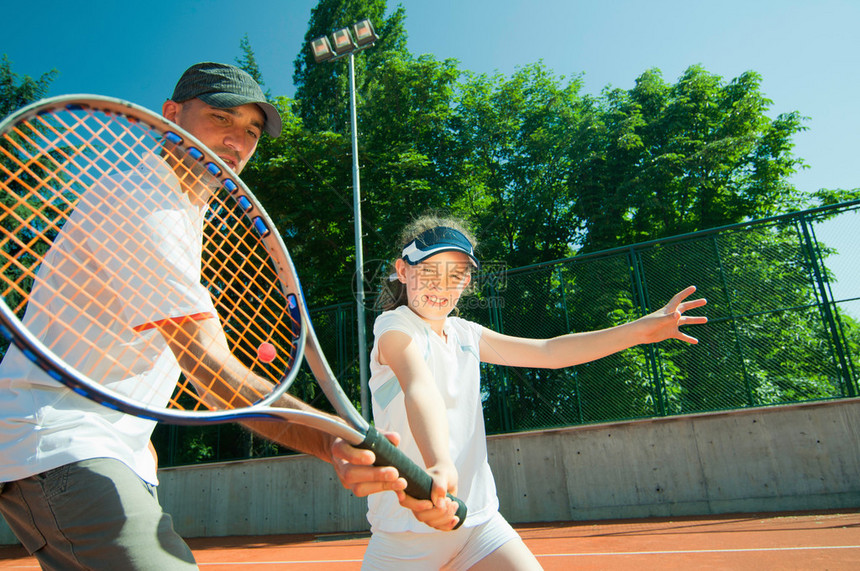 与小网球运动员合作的教练宽角图片