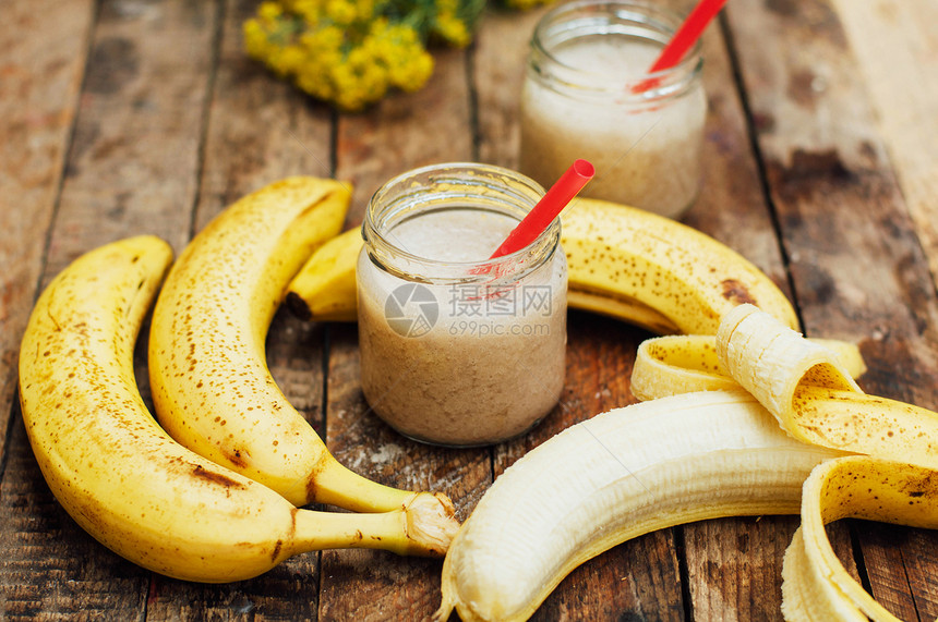 水果冰沙香蕉奶昔加牛奶木桌上的香蕉冰沙健康早餐图片