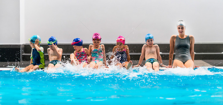 儿童游泳学校游泳教练与一群图片