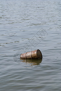 水污染污染河流中的浮动油桶图片