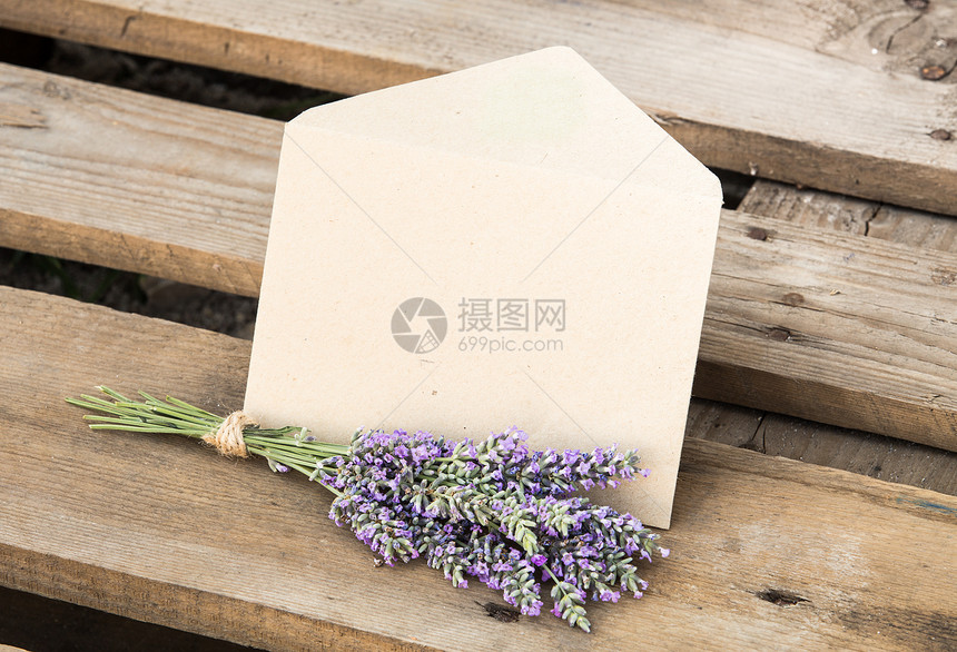 木制背景上的鲜花和信封图片