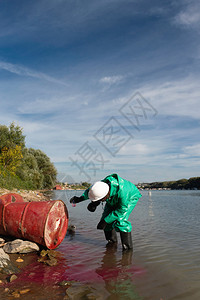 在河附近采集有毒物质样本的环保主义者图片