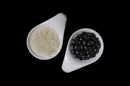 白米和黑豆巴西的feijoada用白色勺子遮住黑色背景图片