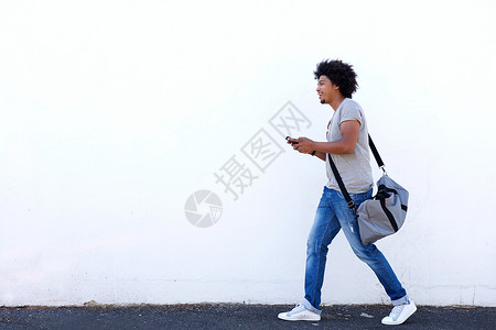 一名青年男子用手提袋和手机行图片