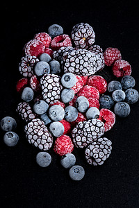 黑色石桌上冷冻的森林水果覆盆子蓝莓和黑莓图片
