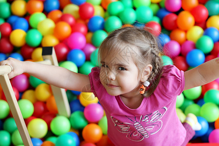 快乐的女孩在幼儿园玩彩球家庭周末概念生日快图片