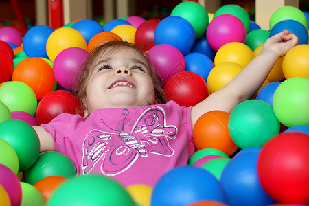 快乐的女孩在幼儿园玩彩球家庭周末概念生日快图片