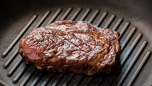 炸锅上的肉黑色的肉餐馆煮的里比牛排图片