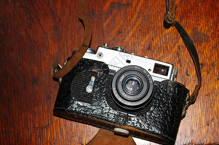 旧木桌上的复古老式照片相机图片