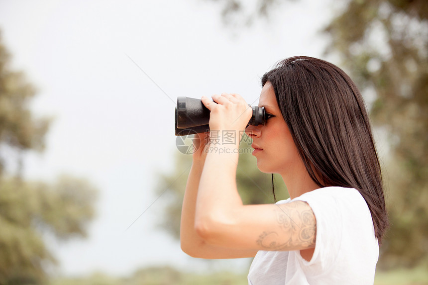 公园的布朗特女人通过望远图片