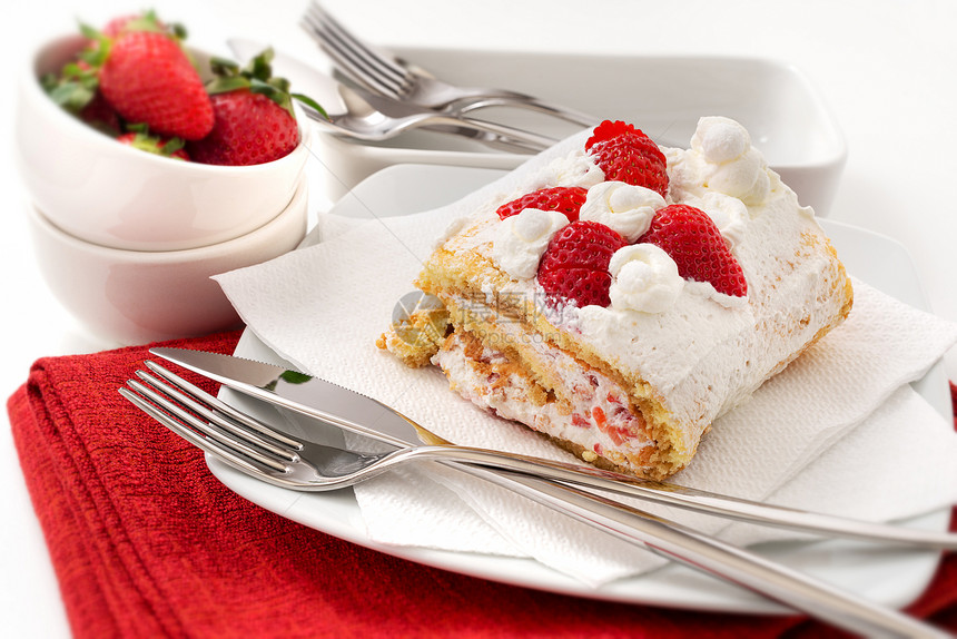 一块带有奶油和草莓的海绵蛋糕卷图片