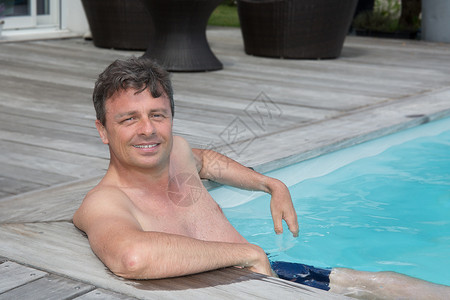 一个成熟男人坐在游泳池里的肖像图片