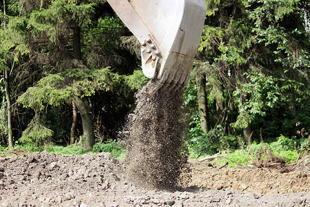 挖掘机铲斗的肮脏工作它在道路维修时挖图片