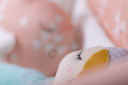 白色和橙色婴儿床有软枕头的图片