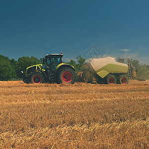 收获金色成熟玉米田的收割机农业机器拖拉机-具有工业主题的图片