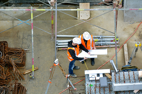 两名未经承认的土木工程师对建筑工地进行视察的空中观察背景图片
