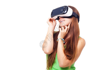 快乐笑容的年轻漂亮女孩利用虚拟现实的VR头套眼镜体验经历的景图片