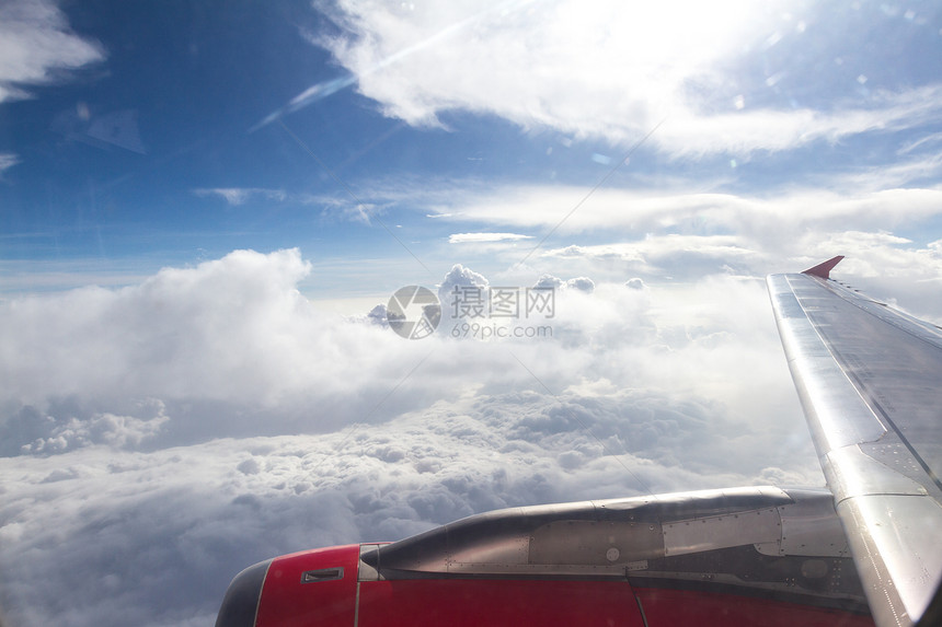 从架子上部分机翼的飞机窗口看到高耸的图片