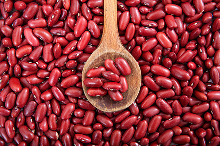 未加工的红豆背景和一个木勺图片