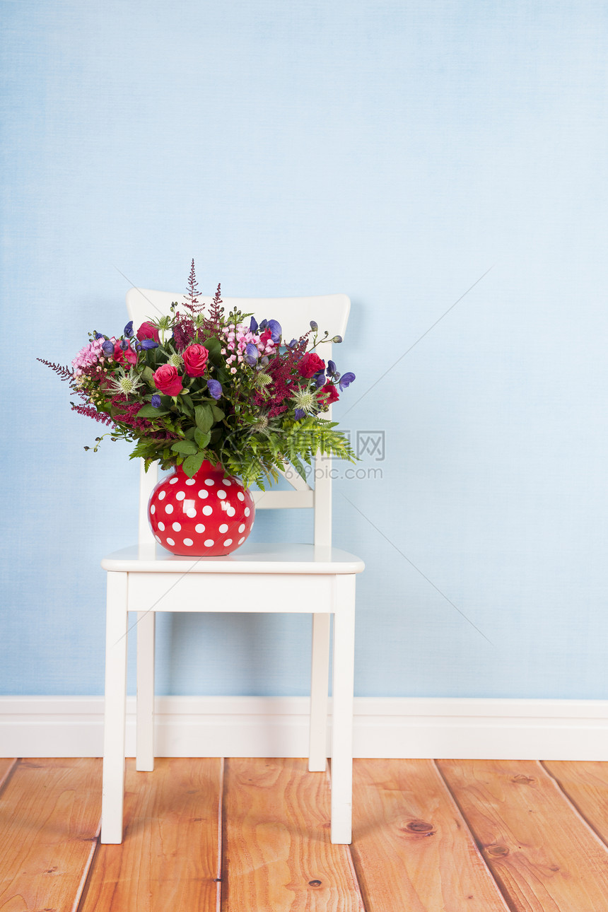 蓝色背景椅子上的混合花束图片