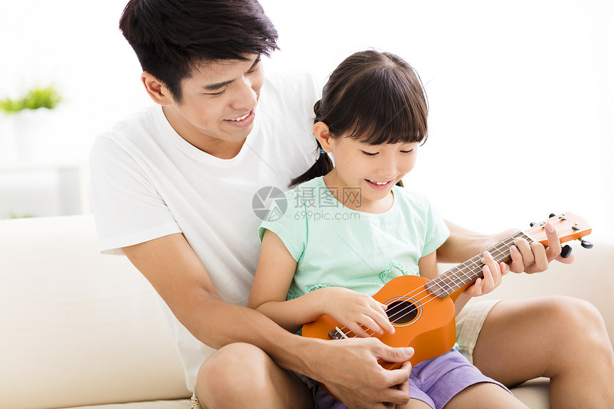快乐的父亲教女儿弹尤克里图片