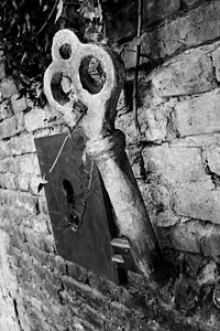 砖墙上的老式巨型钥匙和钥匙孔图片