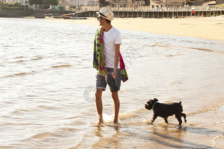 和狗一起走在沙滩上夏天晚上图片