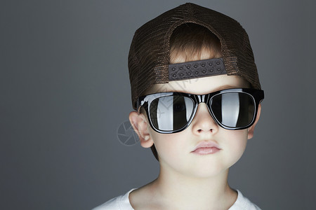 小男孩时装儿童在太阳镜和追踪器帽子上很帅气严重的图片