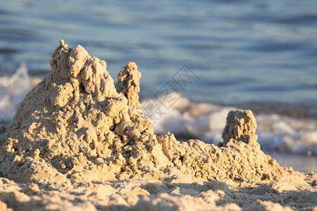 在沙滩蓝海的南岸建有塔楼的房屋沙堡背景图片