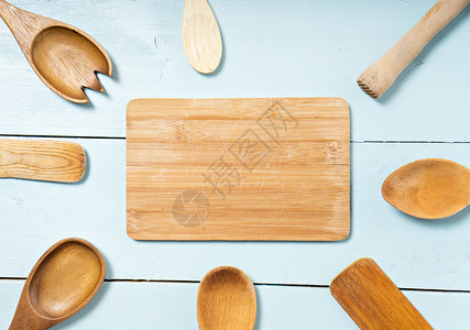 蓝色桌子背景上带木板的木制厨房设备图片