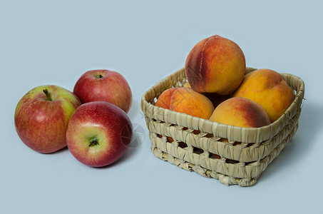 夏季桃子成熟水果放在一个有红苹果背景图片