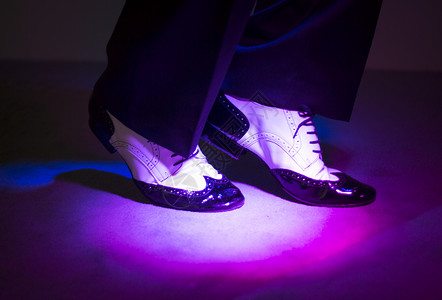 男拉丁和萨尔舞者穿着黑白爵士舞鞋在舞台上图片