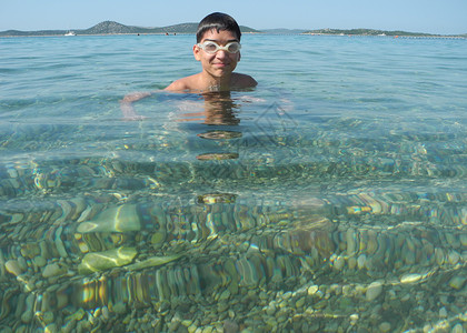 高兴的男孩从海里游泳图片