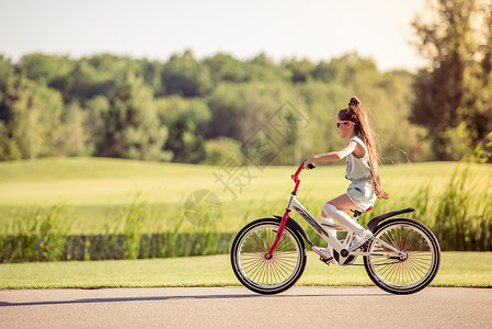 外出骑自行车的戴眼镜的时装小女图片