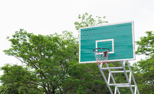 公园里的篮球架以绿树为背景背景图片