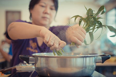 亚洲女在烹饪食物时图片