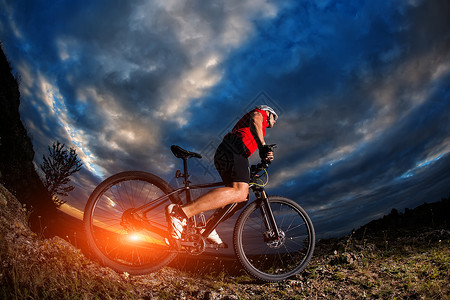 山上的山上骑自行车者日出和云图片