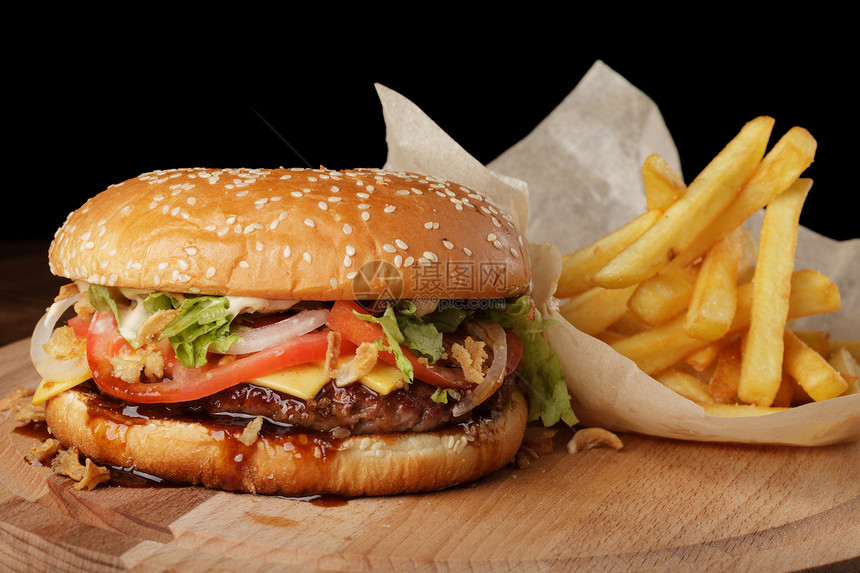 奶酪汉堡汉堡配有薯条和酱汁黑木图片