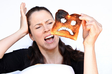 女人用不开心的笑脸在烧焦的烤面包上尖叫图片