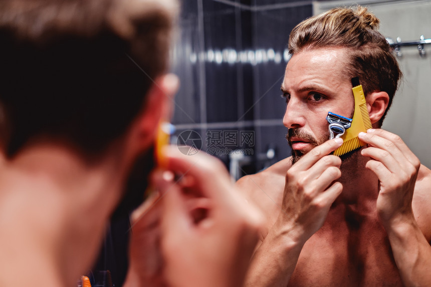 时髦男人在浴室里刮胡子图片