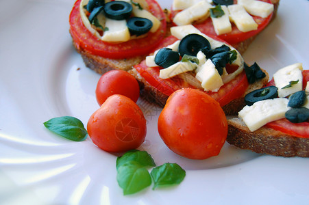 Bruschetta配西红柿黑橄榄山羊奶酪草药和图片