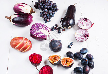 木制背景上新鲜紫色水果和蔬菜的集合图片